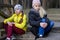 Two sisters drinking a refreshment sitting by the lake in the afternoon.