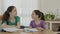 Two sisters fighting and laughing while preparing homework
