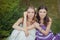 Two sisters friends blond brunette blue eyes lady girls posing together summer sunny day evening dressed in white purple airy dinn