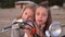 Two sisters have fun together. Two girls pose on the beach at the white moped.