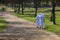 Two sisters (nuns) walking in a park along the path.