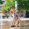 Two sisters playing with fountain splash