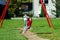 Two sisters playing in the playground, sunny day