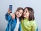 Two sisters posing and taking selfies in the studio