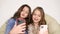 Two sisters take selfies at home, smiling friends taking a self shot with phone