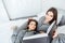 Two sisters twins reading book and lying on bed together