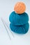 Two skeins of yarn and a turquoise orange yarn and knitting needles