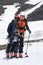 Two ski mountaineers climb on mountain on skis strapped to climbing skins