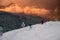 Two skiers descend slope against the backdrop of winter mountain scenery