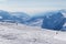 Two skiers downhill on snow off-piste slope and mountains in haze