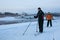 Two skiers enjoy the snow and view of Volkhov river in Velikiy