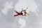 Two skydivers are in the winter sky.