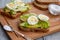 two sliced ripe avocado sandwiches with egg and spices on a wooden Board. Top view. Healthy breakfast