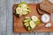 two sliced ripe avocado sandwiches with egg and spices on a wooden Board. Top view. Keto diet