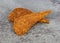 Two slices of duck jerky on a gray mottled background