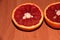 Two slices of Sicilian orange on a wooden background