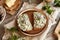 Two slices of sourdough bread with nettle butter and fresh lungwort flowers - wild edible plants collected in spring