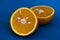 Two slices of tangerine on a blue chopping Board