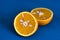 Two slices of tangerine on a blue chopping Board