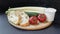 Two slices of white beautiful airy white bread, yogurt, fresh vegetables - cucumbers, tomatoes and celery, all on a round wooden