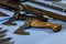 Two small axes with wooden handles on a table among knives and sabers. Close-up.