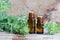 Two small bottles with essential wormwood oil extract, tincture, infusion. Old wooden background. Aromatherapy, spa and herbal