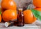 Two small bottles with orange mandarin essential oil tangerine extract, tincture, infusion, perfume. Aromatherapy and spa