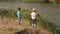 Two small boys throw stones into the lake.