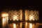 Two small burning candles on dark background