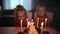 Two small charming and dressed twin sisters gathered near the festive cake with burning candles. Birthday in the family.