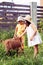 Two small children graze goats near a house in the village