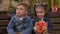 Two small children sit on a Park bench, a girl holding a bouquet of flowers.