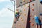 Two small climbers conquer the summit of an artificial mountain in a sports amusement park