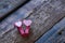 Two small clothespins hearts lie on a wooden table. Love