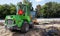 Two small excavators on a large construction site. Bright green on wheels and yellow on tracks. Earthworks and construction.