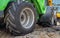 Two small excavators on a large construction site. Bright green on wheels and yellow on tracks. Earthworks and construction.