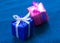 Two small gift decorative boxes on a blue background.