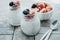 Two small jars of chia pudding, yogurt and fresh fruits: Strawb