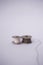 Two small spools of sewing thread of various colors isolated on a white background and also with a small sewing needle stuck in th