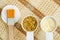 Two small white bowls with dry calendula flowers and herbal mask face cream for natural skincare and medicinal purposes.