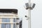 Two small white CCTV cameras and loudspeaker speakers on a pole