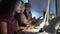 Two smart business women working together with computer and digital tablet while talking in the office.