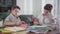 Two smart Caucasian twin brothers drawing at home with colorful pencils. Schoolboys doing homework together. Creative