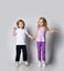 Two smiling blond kids boy and girl in casual stylish clothes jump together having fun