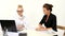 Two smiling businesswomen working with laptop in