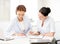 Two smiling businesswomen working in office