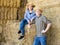 Two smiling farm workers resting on hayloft at cow farm