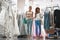 Two smiling ladies choosing dress in salon