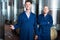 Two smiling men in uniforms standing in winery fermentation comp