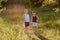 Two smiling preschool boys hold hands in summer in counter light